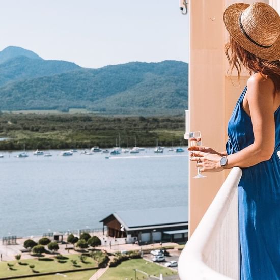 A lady on a balcony enjoying the harbour view at Pullman Cairns