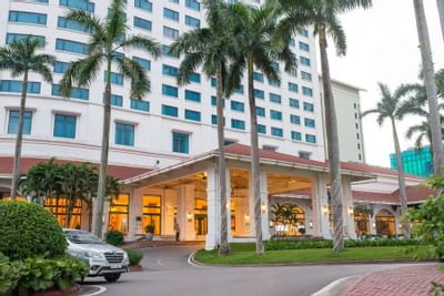A palm tree-lined main entrance to the Hanoi Daewoo Hotel