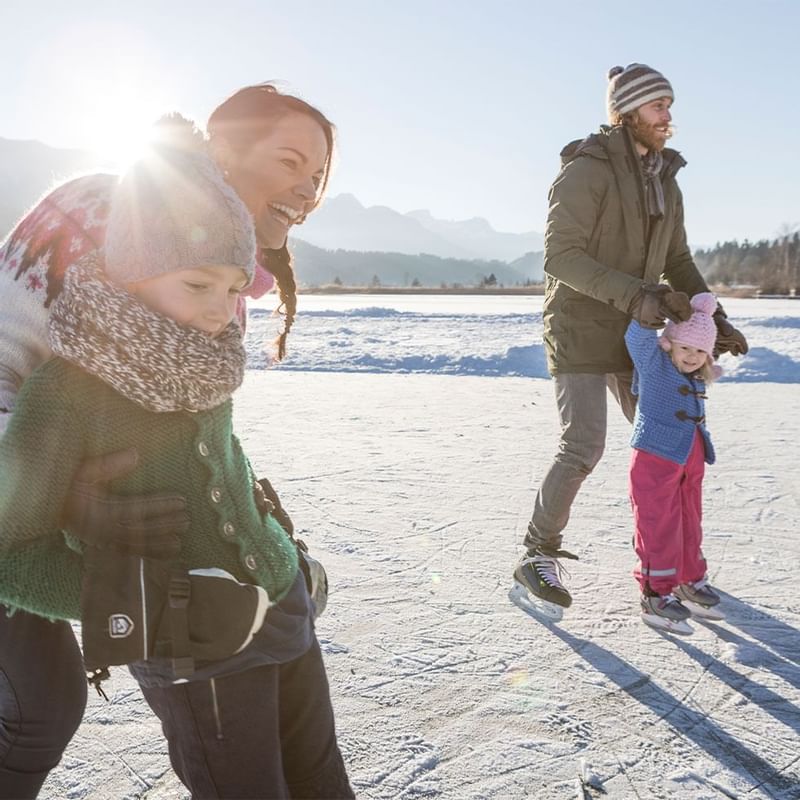 A family enjoying the snow near Falkensteiner Hotels