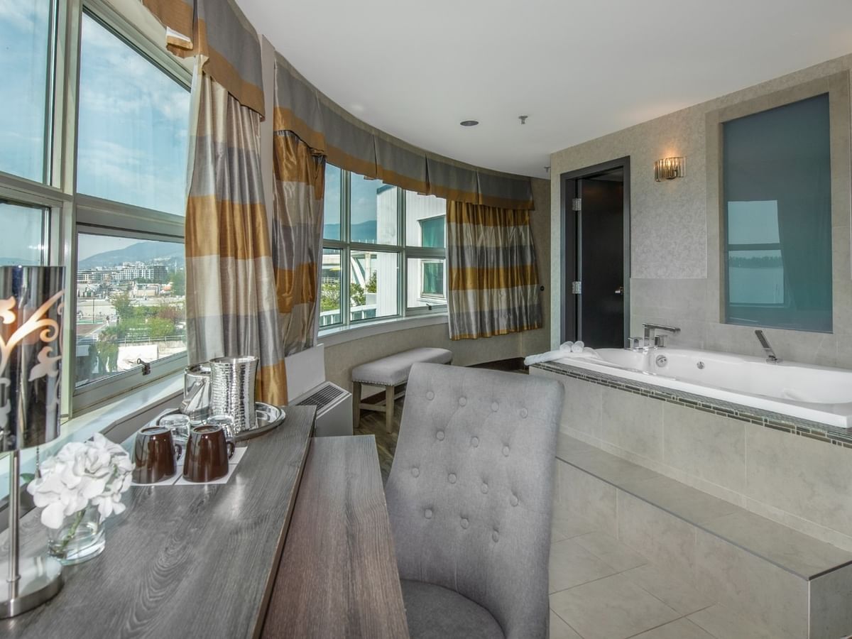 Coast Carrie Cates Penthouse Suite 
with a large bathtub and a window with a city view at Coast Lonsdale Quay Hotel