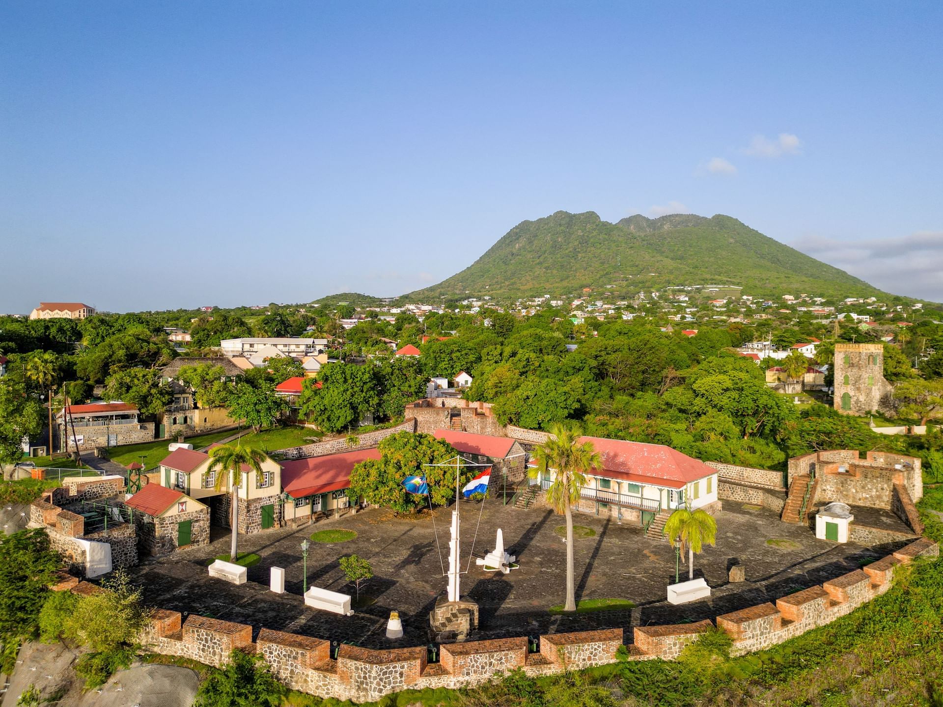 Aerial view of Caribbean landscape with historic buildings and green mountain near Golden Rock Resort