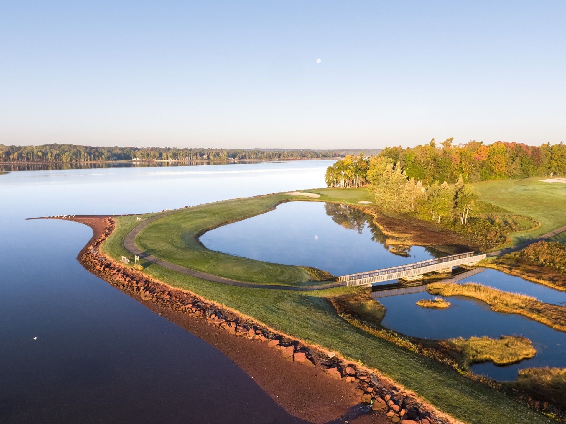 Stone bridge over a quiet lake & a green shore near Rodd Brudenell River Resort, one of the best Brudenell River golf courses