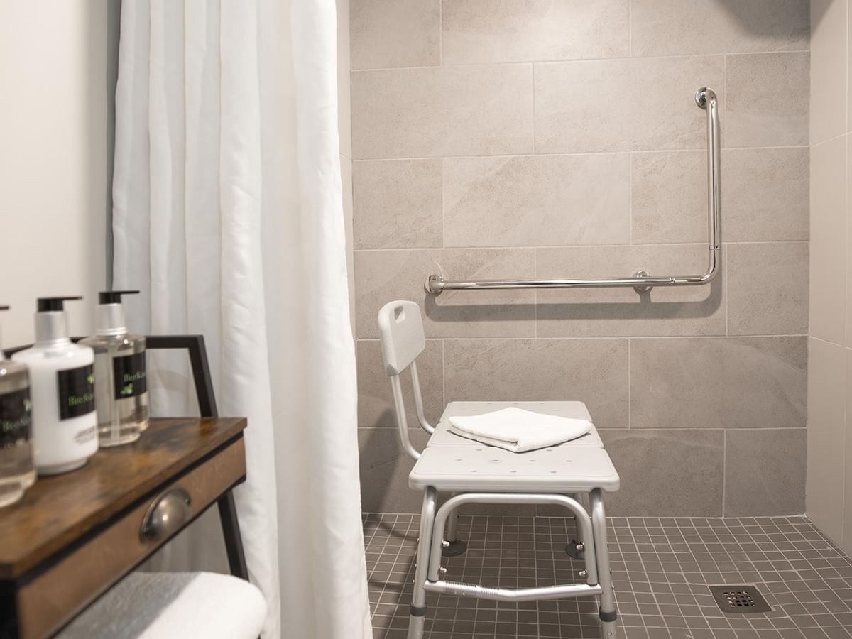 Accessible bathroom with shower chair and grab bars.
