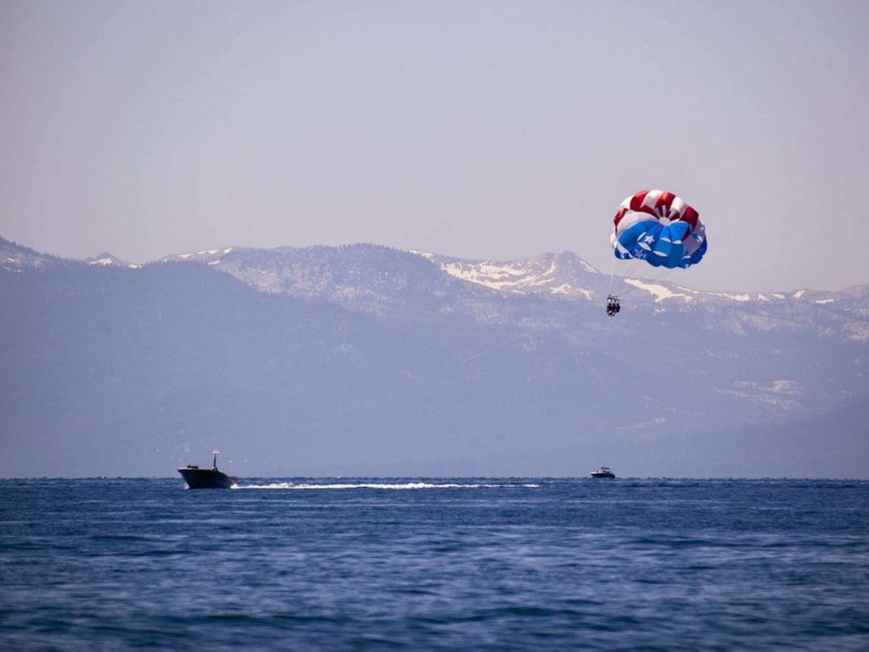 People parasailing in Lake Tahoe near Stay Hotel Waikiki