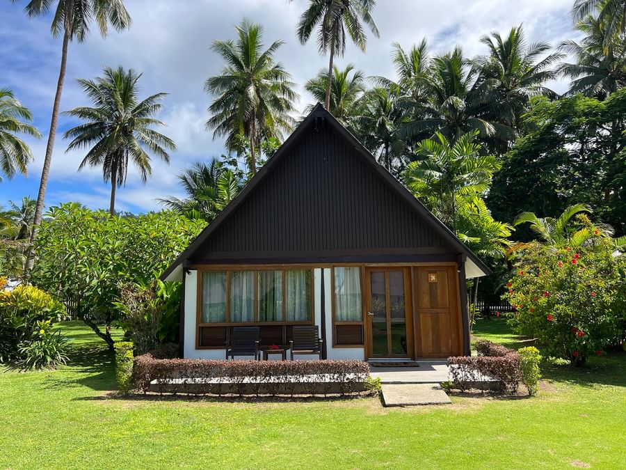 Bungalow at Tambua Sands Beach Resort in Fiji with tropical surroundings and palm trees.