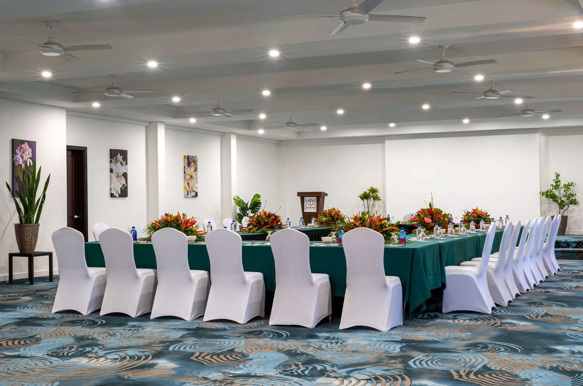 Table with green cloths and floral centerpieces by white chairs in Conference Room 1 at TokaToka Resort Nadi Fiji