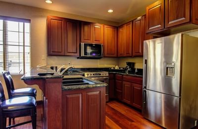 Modern kitchen featuring wood cabinets and stainless steel appliances in the Presidential Suite at The Wildwood Hotel