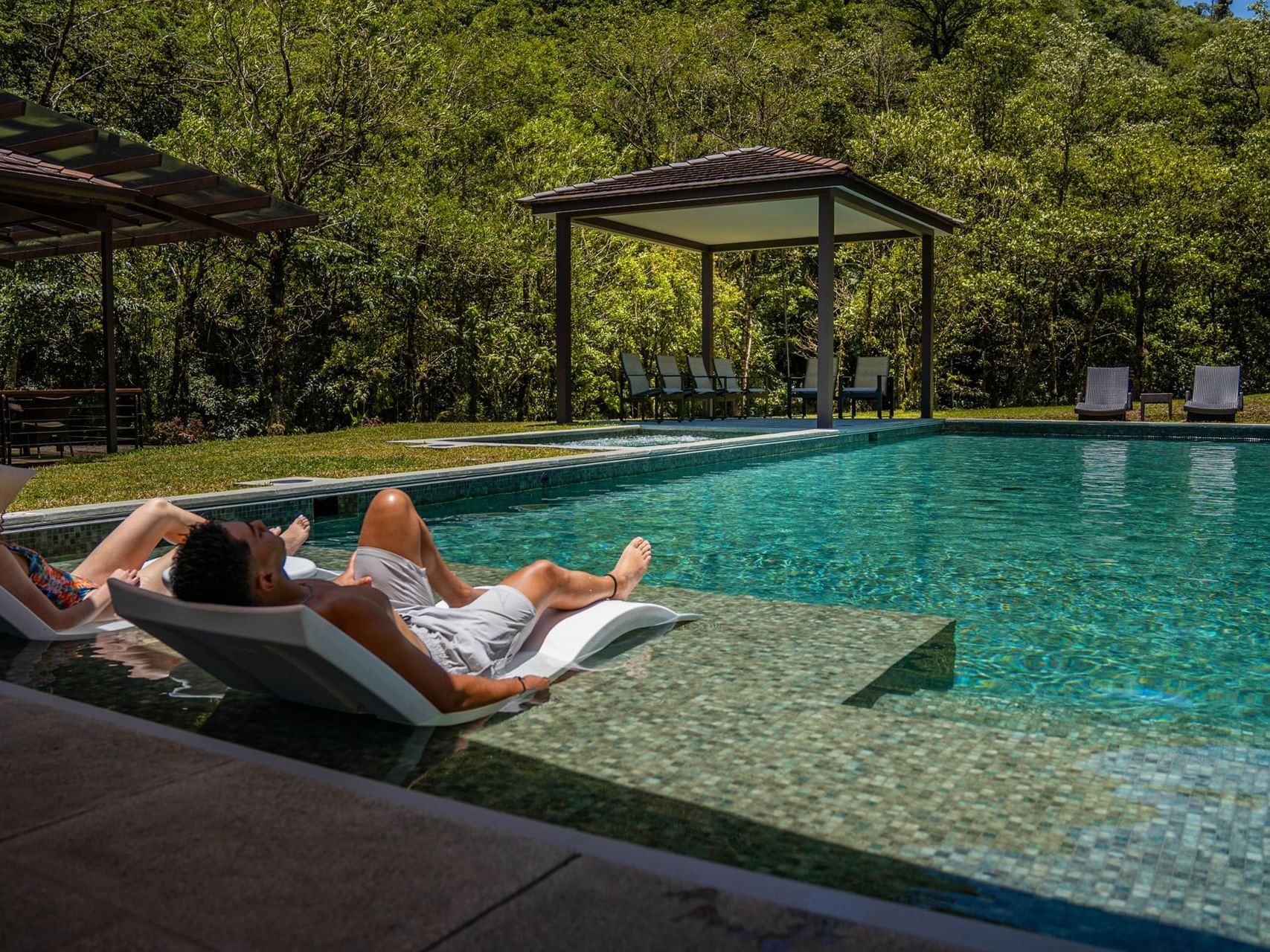 Couple relaxing in outdoor pool area at El Silencio Lodge and Spa