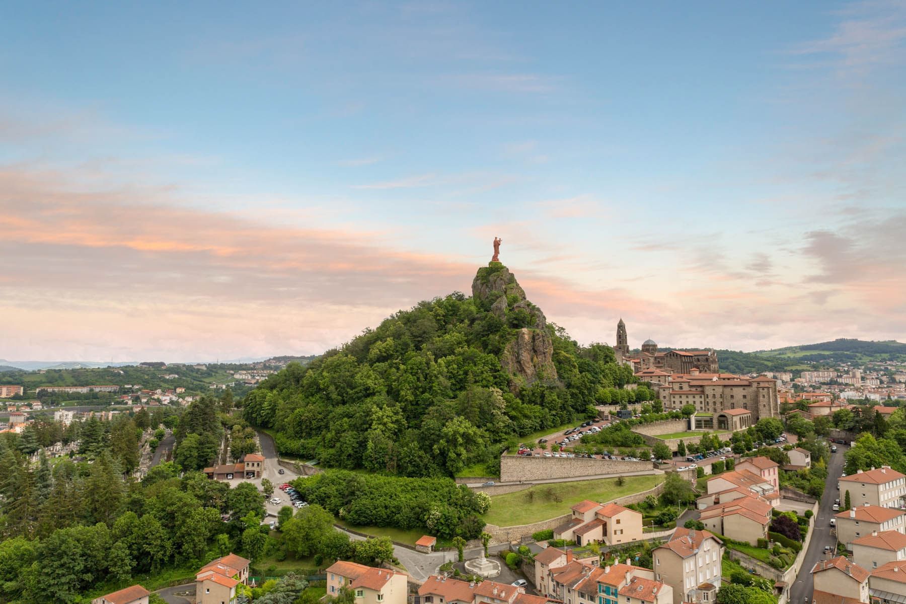 A mountain range surrounded with buildings and trees 