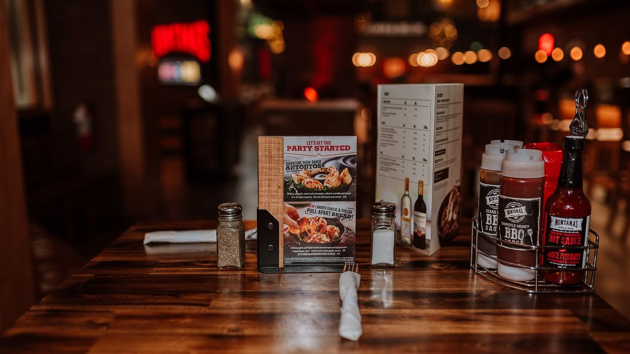 Table with menu, condiments, and a party flyer at Montana's.