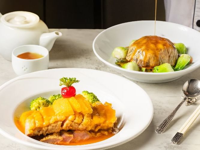 A table set with a plate of food and a bowl of soup, showcasing a delightful meal ready to be enjoyed.