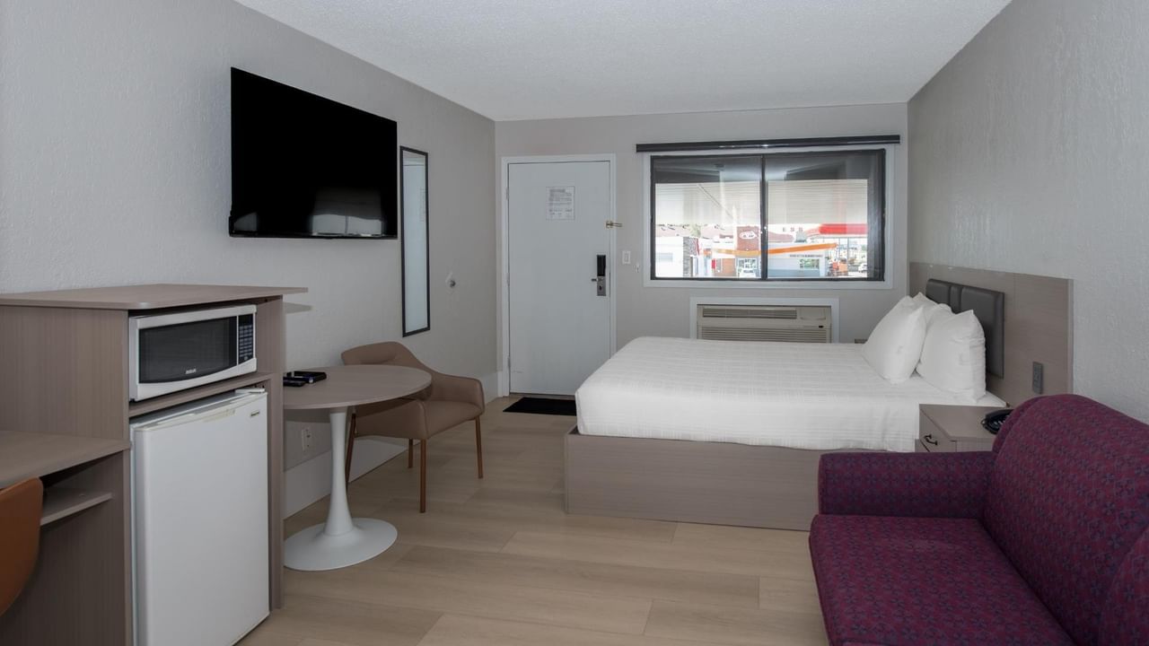 Guest room at Coast Red Deer Hotel with queen bed, TV and sofa