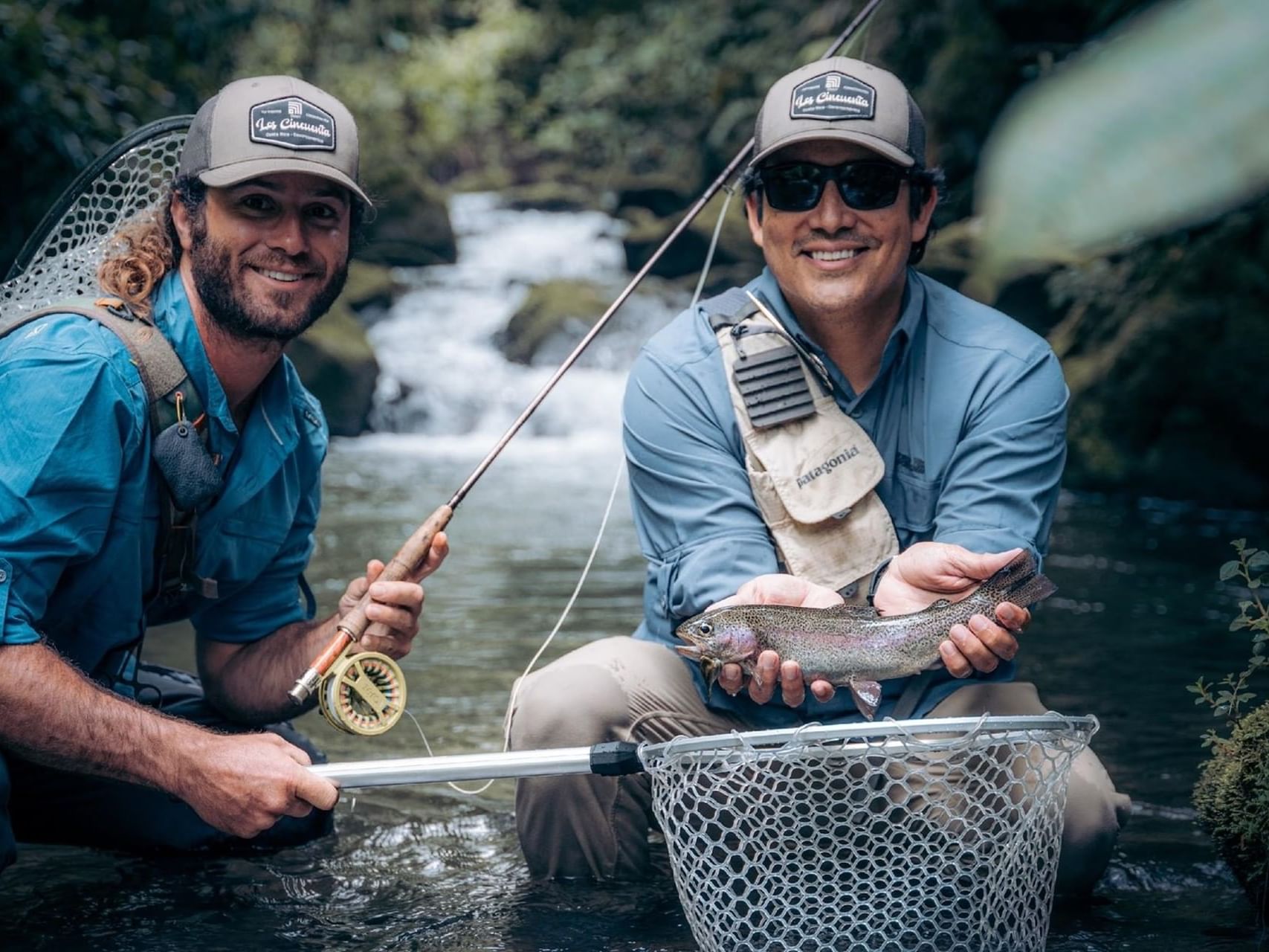 Two individuals holding a fishing rod and the caught fish in Gorrion River near El Silencio Lodge and Spa