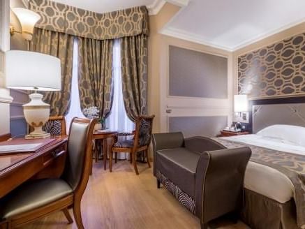 Work desk, lamps, comfy sofa & king bed in Classic Queen Room at Grand Visconti Palace