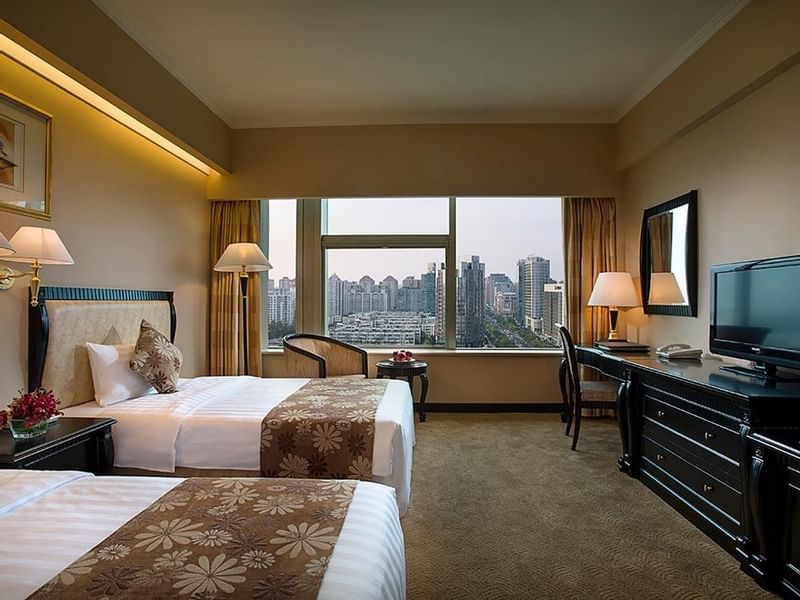 Twin beds, work desk & a TV in Standard Room at Celebrity International Grand Hotel