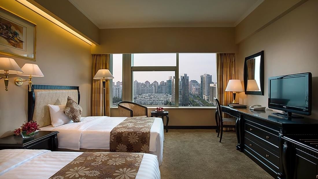 Twin beds, work desk & a TV in Standard Room at Celebrity International Grand Hotel