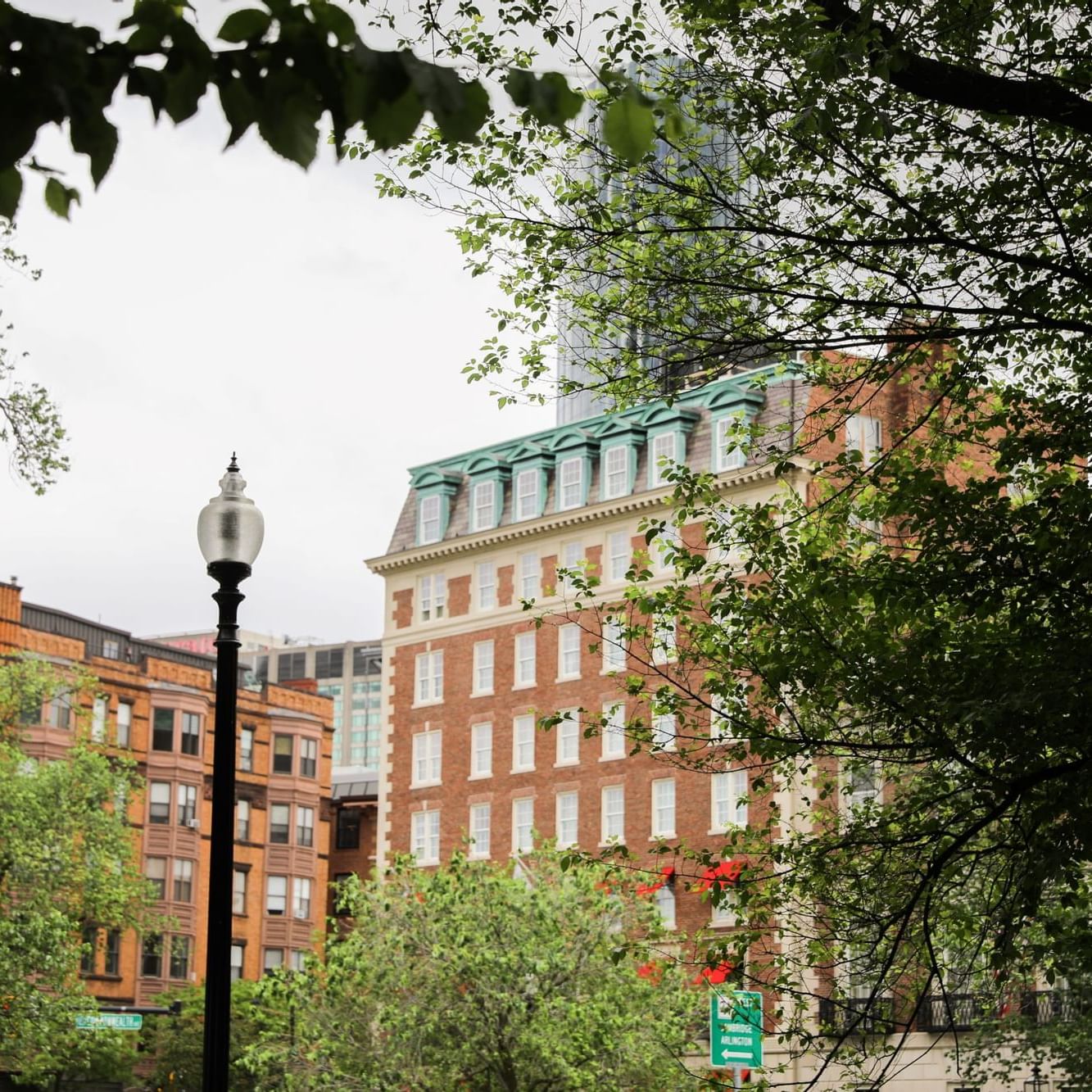 A distant exterior view of The Eliot Hotel through trees