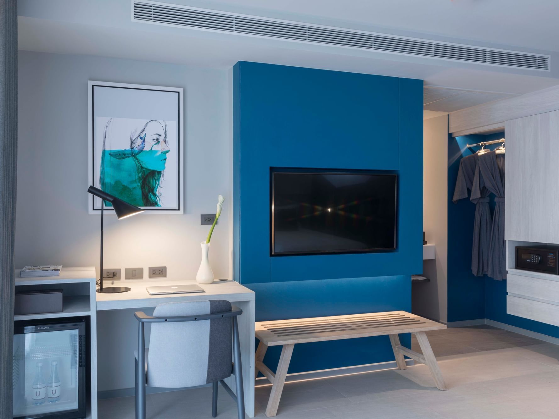 Living area with a TV, desk in Deluxe Triple Room at U Hotels
