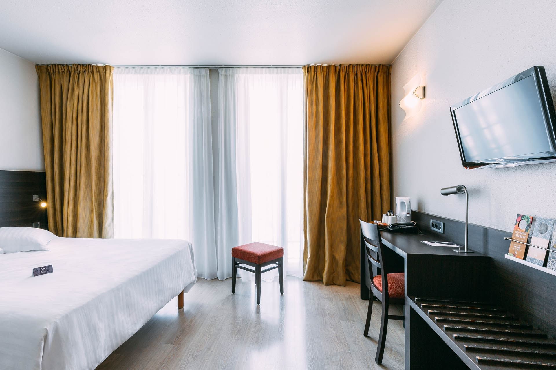 Lit king-size et bureau dans une chambre à l'Escale Oceania Marseille