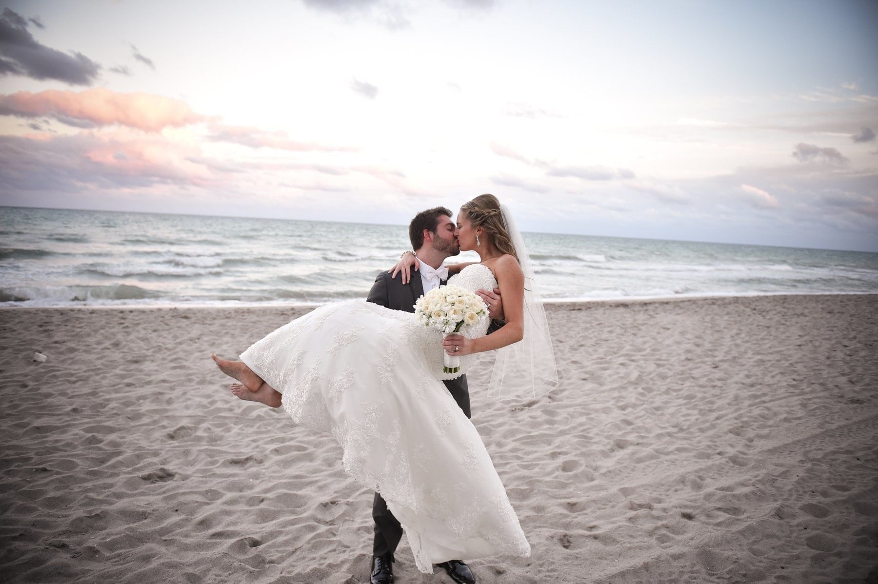 Groom posing with the Bride on the Beach at Diplomat Resort
