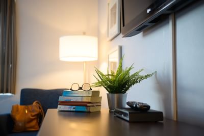 Close-up of books with glasses and potted plant in King Room Street View at Rodd Moncton, a classic place to stay in Moncton