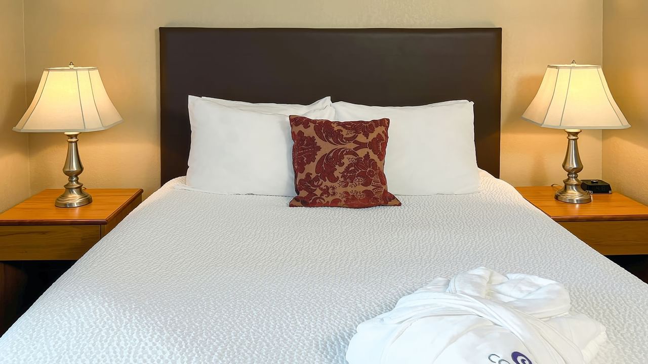 Hotel room with bed, bath robe, and lamps