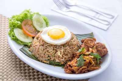 A plate of fried rice with egg, salad, and crispy chicken at The Saujana Hotel Kuala Lumpur