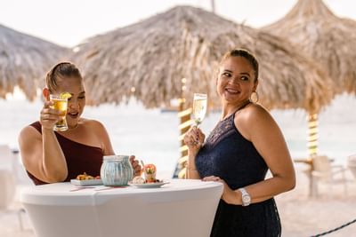 2 Ladies enjoying drinks by the beach at Amsterdam Manor Resort