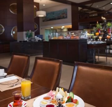 A cup of tea and a juice glass served with desserts on a table in Alesta Restaurant at Titanic Business Kartal