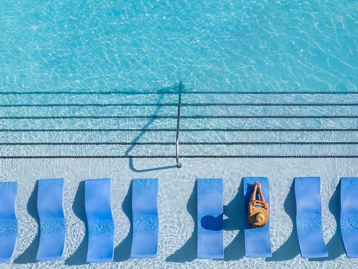 Luxury pool at Shangri-La Resort and Golf Club, with blue loungers submerged in clear water under the sun