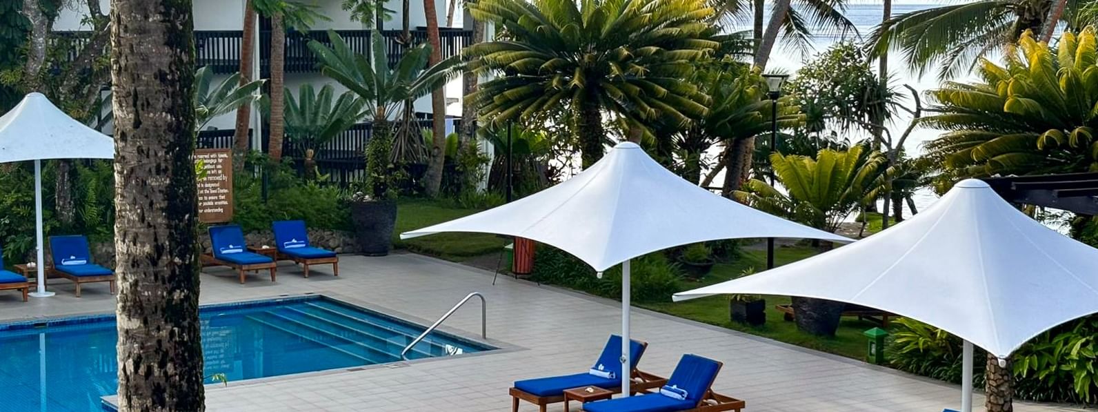 Adult Only Pool & Bar with blue loungers and white umbrellas at Warwick Fiji Resort and Spa, Korolevu