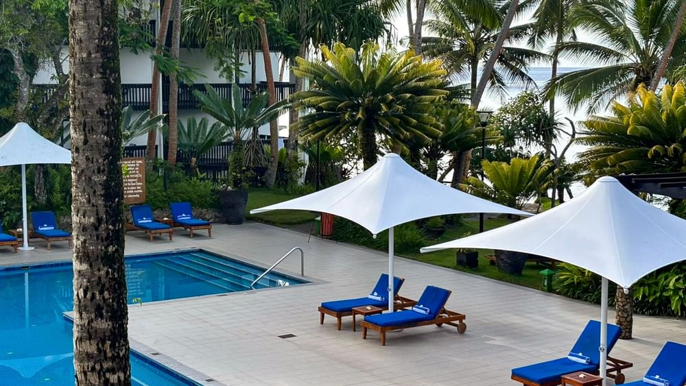 Adult Only Pool & Bar with blue loungers and white umbrellas at Warwick Fiji Resort and Spa, Korolevu.