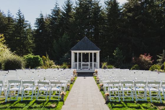 White ceremony chairs arranged by a brick path at Oregon Garden Resort, a premier Oregon garden wedding