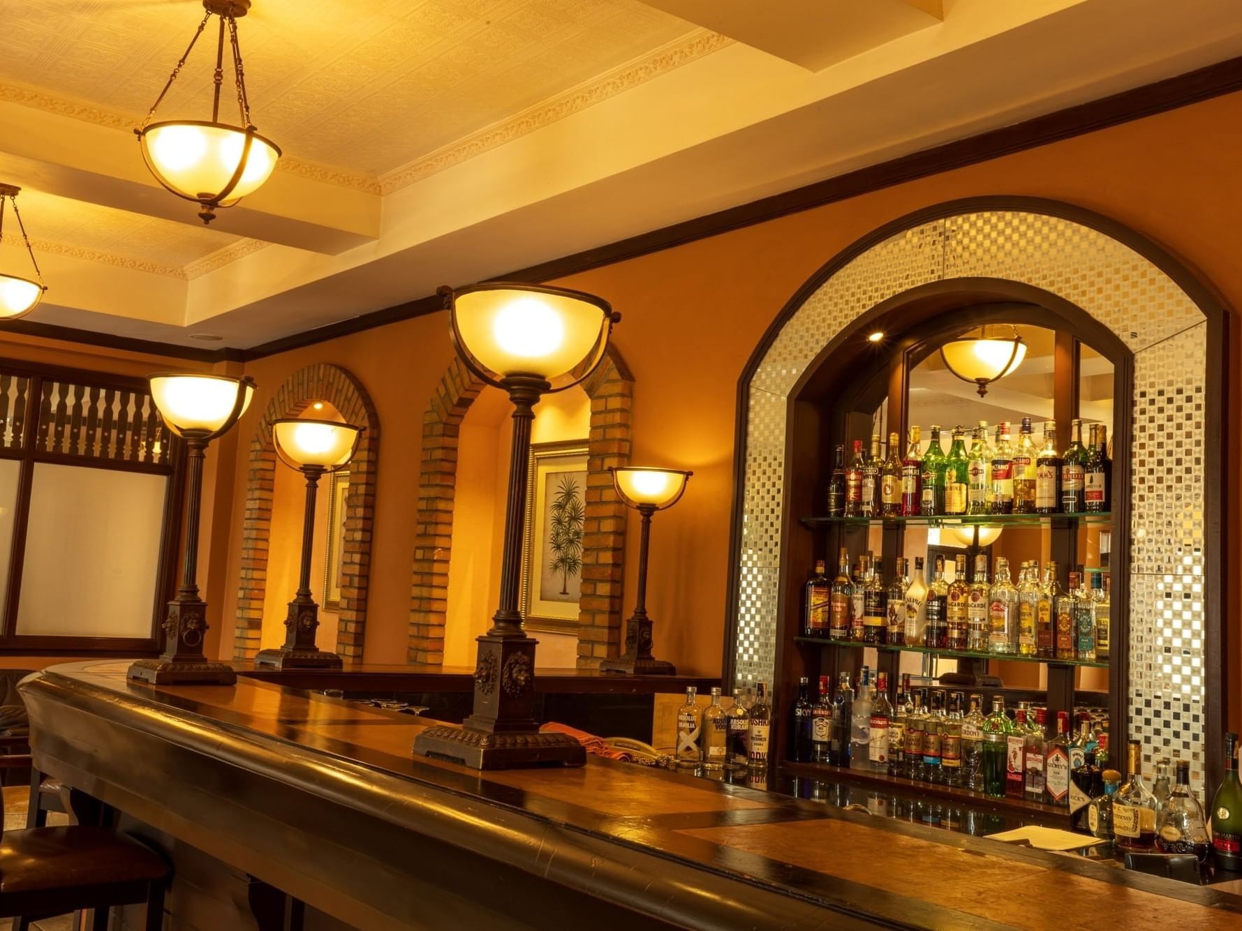 Kigo Bar with shelves of bottles and ceiling lamps at Lake Victoria Serena Golf Resort & Spa in Kampala.