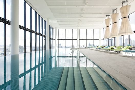 Indoor pool area with pool chairs at Crown Metropol Melbourne
