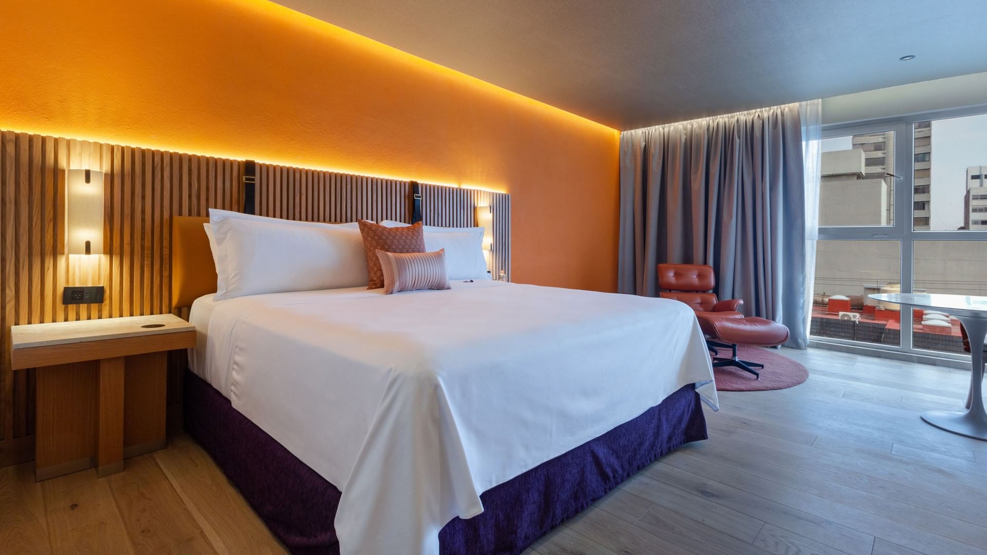 King Superior Camino Real Club with a slatted wood headboard and a classic leather lounger at Camino Real Polanco Mexico