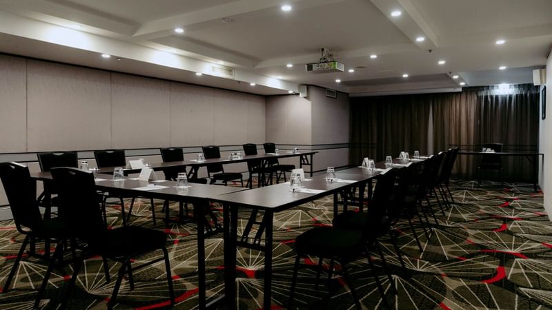 Chairs and tables arranged for meetings in Avalon Room at Novotel Sydney Parramatta.
