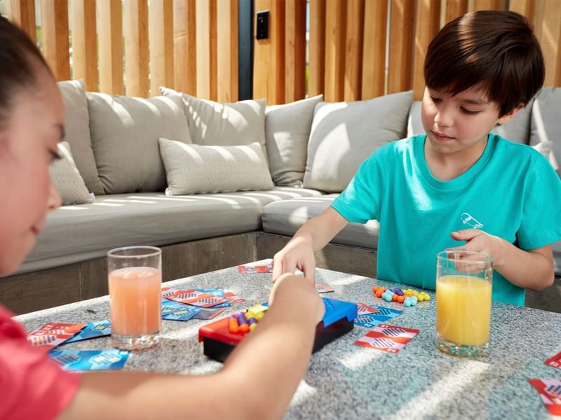 Two children engrossed in a card game at Fiesta Americana