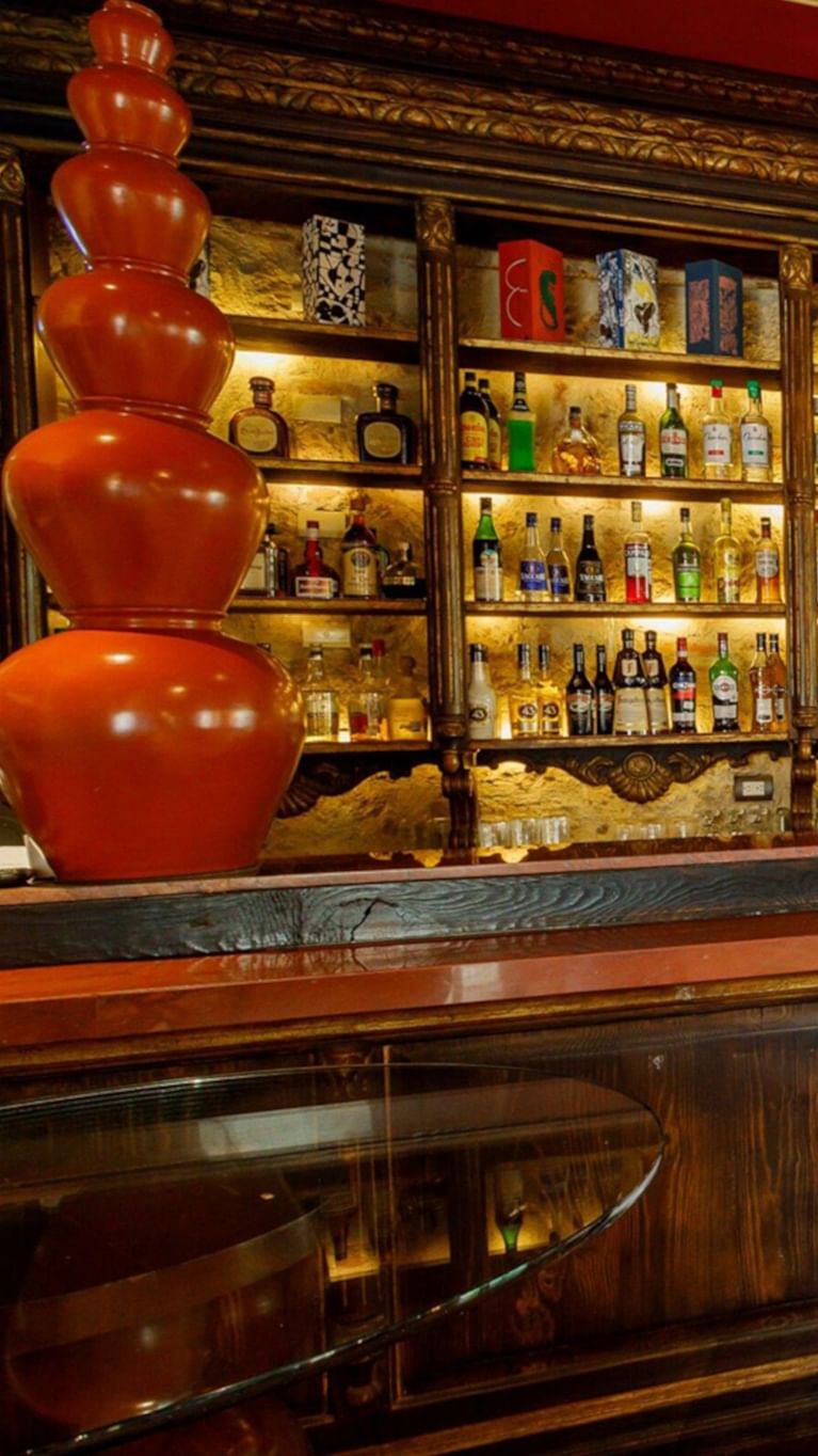 Tierra Mia bar area featuring a tall red tiered sculpture and a lit shelf of premium liquor at Quinta Real Guadalajara