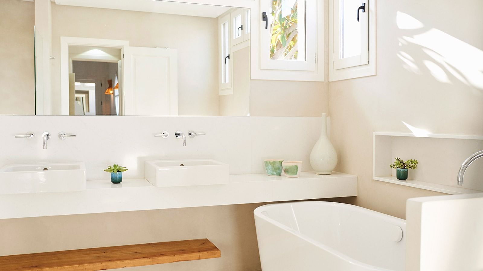 Four-bedroom villa bathroom, featuring a white tub placed under a counter and large mirror in Marbella Club