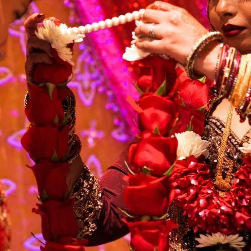 Bride putting garland on husband also known as jai mala a popular Indian wedding tradition