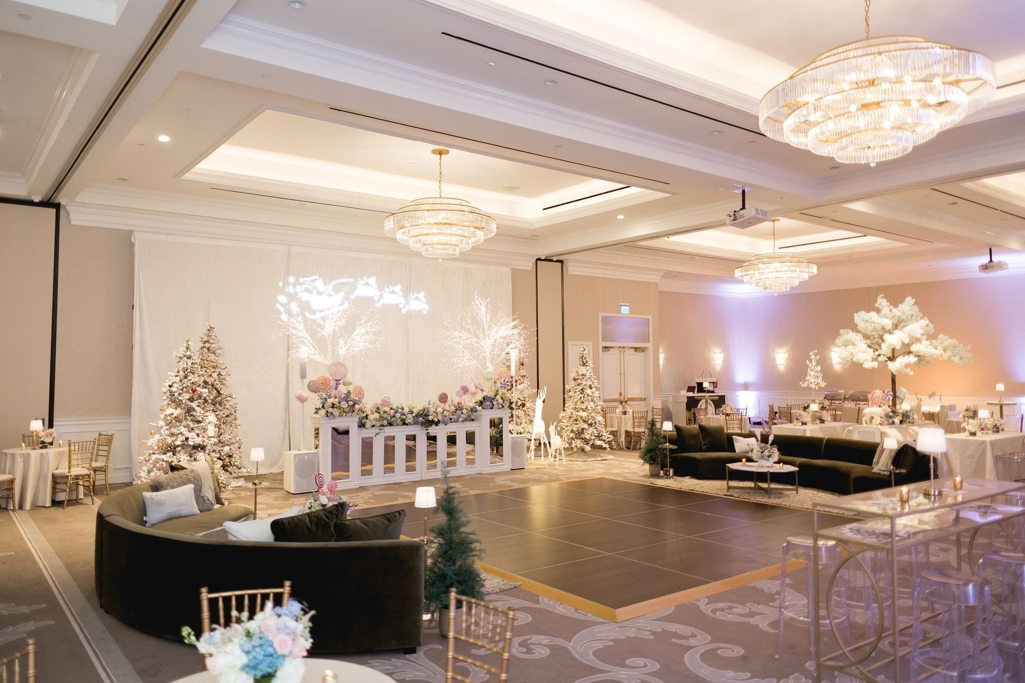 Holiday event with a dark dance floor by velvet sofas under crystal chandeliers at Warwick Melrose Dallas