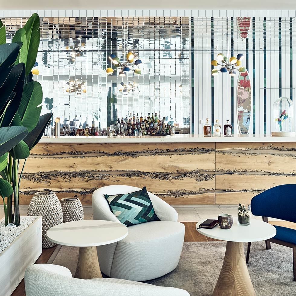 Lounge area with stylish furniture, a bar in the background at Falkensteiner Hotel & Spa Jesolo