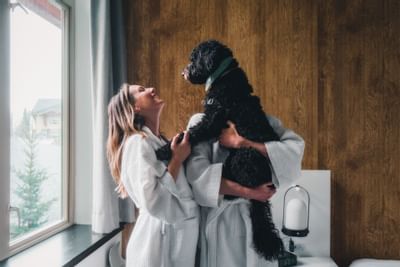 Couple petting a dog in a room at Aava Whistler Hotel