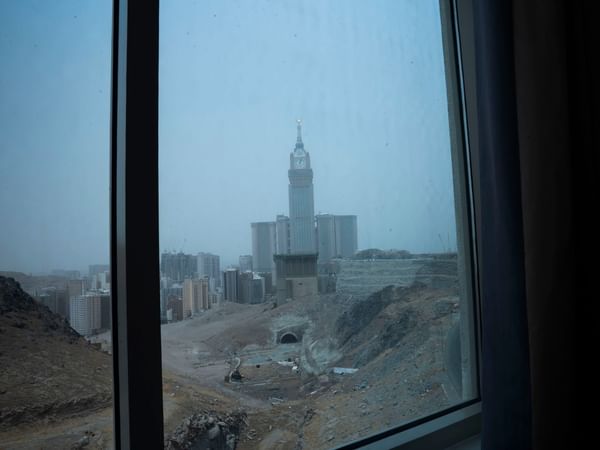 View of city and clock tower through window at Saja by Warwick Makkah.