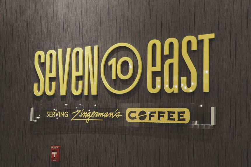 black wall with yellow letters that say seven 10 east coffee