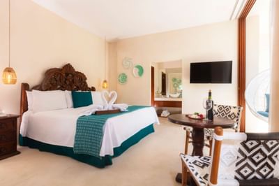 Superior Room featuring a bed near a small wooden dining table with wine & a wall-mounted TV inside Casa Dona Susana