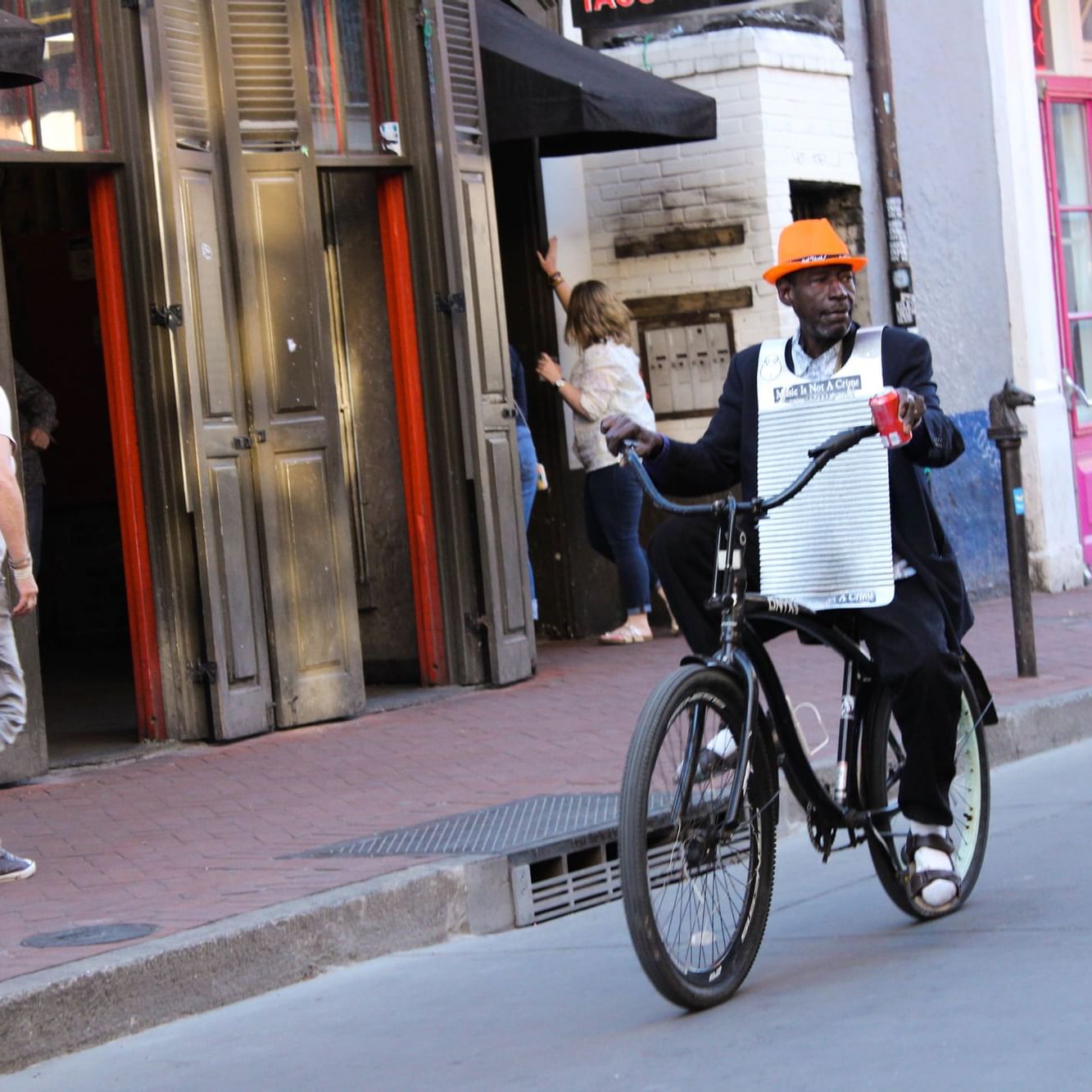 A man riding a bicycle in a street near La Galerie Hotel