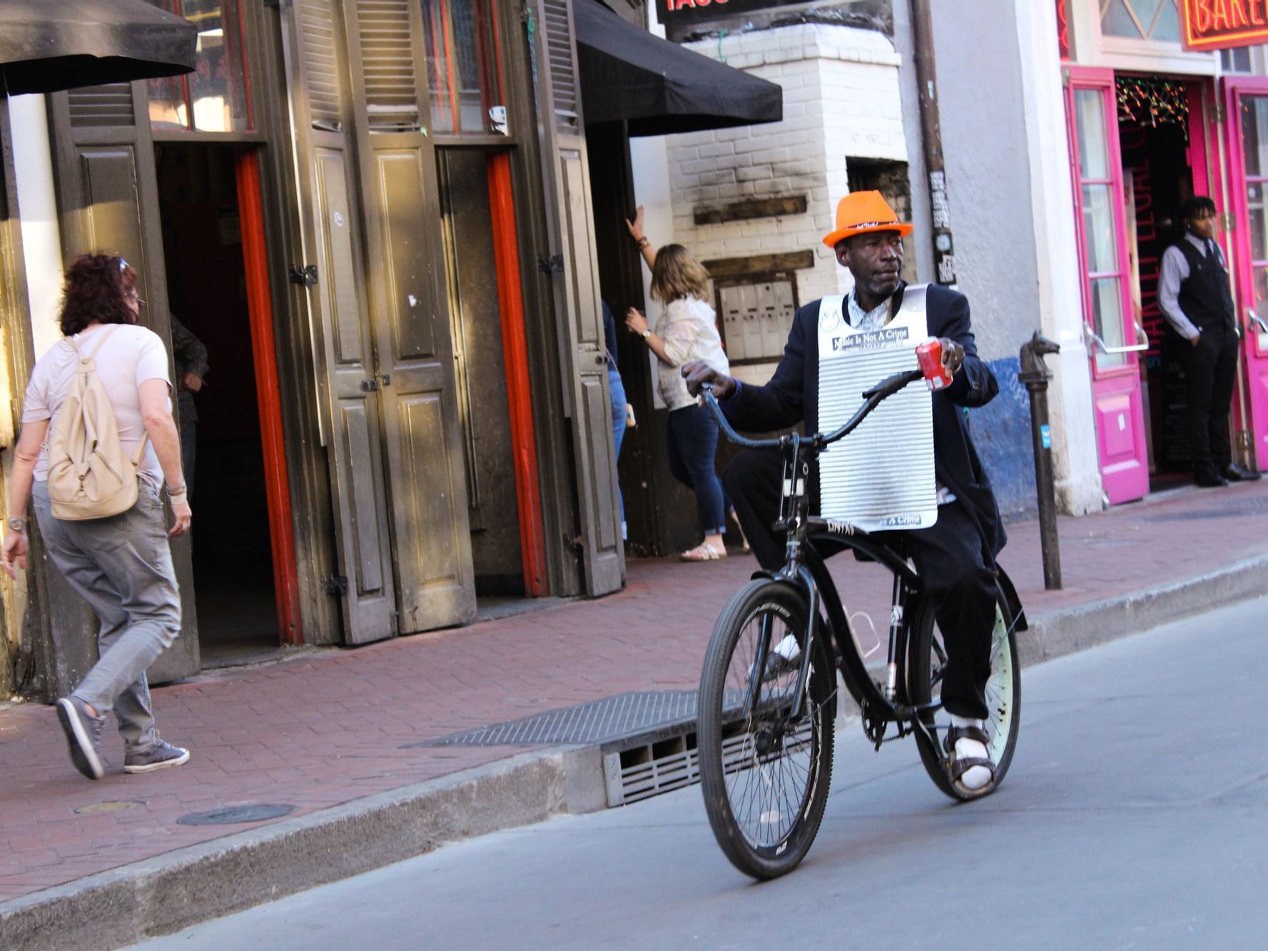 A man riding a bicycle in a street near La Galerie Hotel