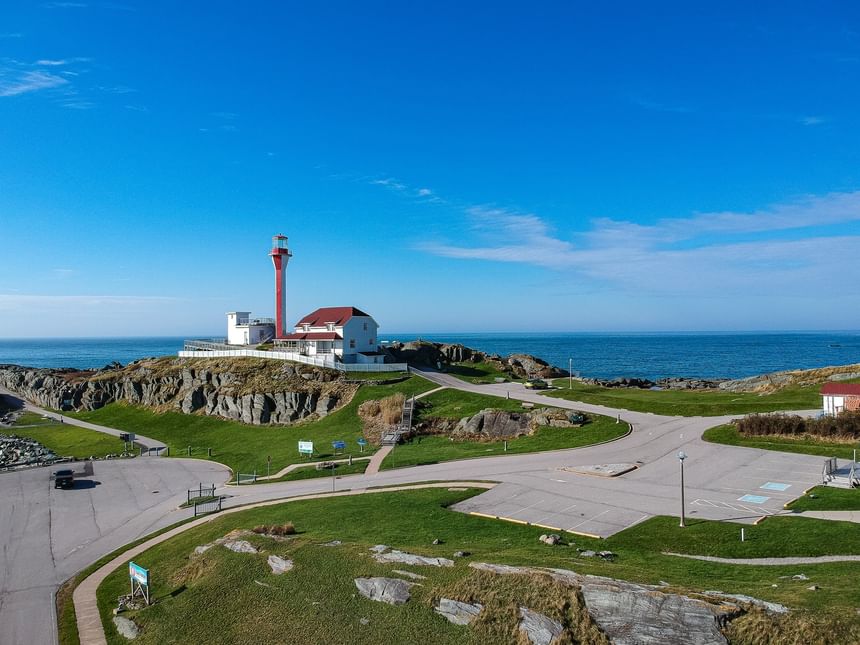 Cape Forchu Lighthouse on a rocky coast under a blue sky near Rodd Grand Yarmouth, one of the best attractions in Yarmouth
